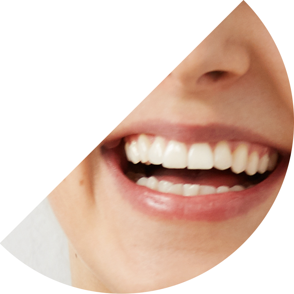 Lächelndes Gesicht gesunden Zähnen vor einer hellgrauen Wand